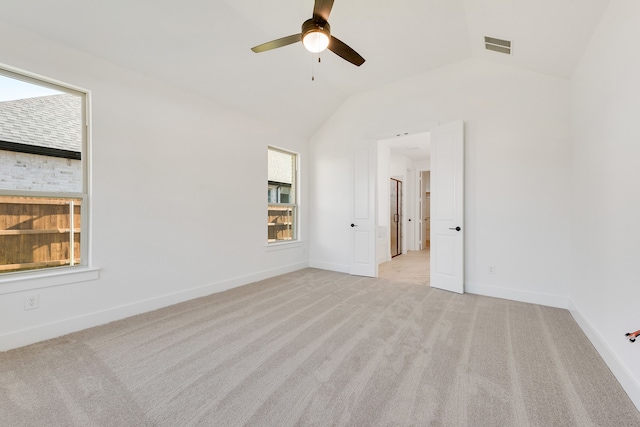 empty room with light carpet, ceiling fan, and vaulted ceiling