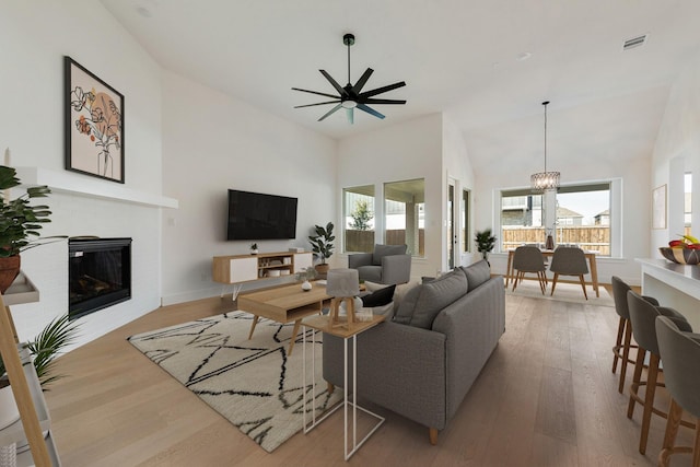 living room with light hardwood / wood-style flooring, a wealth of natural light, and high vaulted ceiling