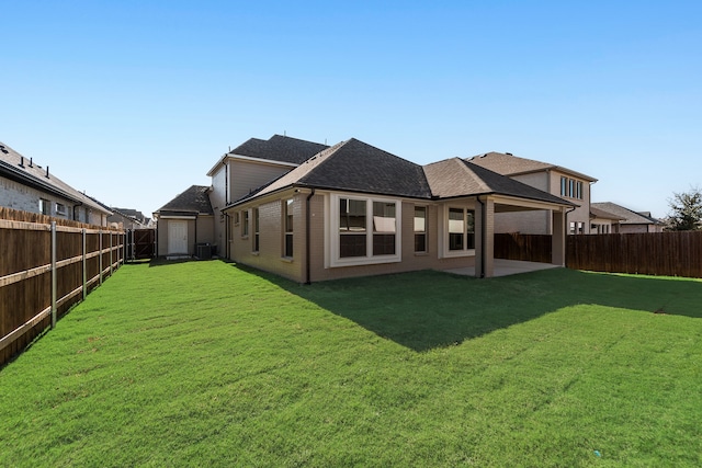 rear view of property featuring cooling unit, a patio area, and a lawn