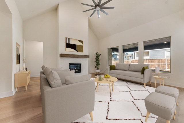 living room with light hardwood / wood-style floors, high vaulted ceiling, and ceiling fan