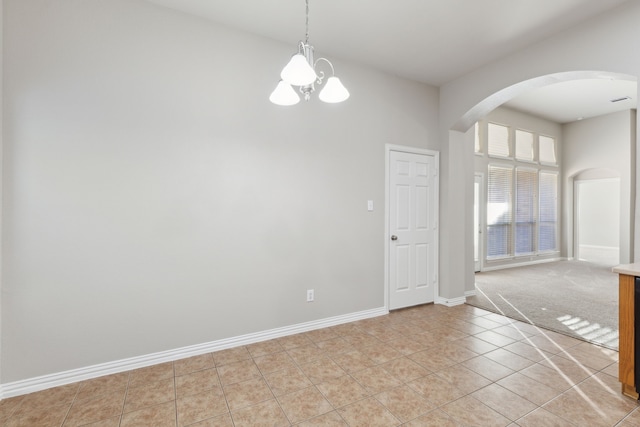 unfurnished room featuring a chandelier and light tile patterned floors