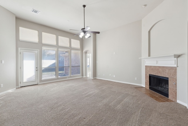 unfurnished living room featuring ceiling fan, a fireplace, and light carpet