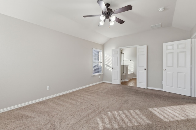 unfurnished bedroom with connected bathroom, ceiling fan, light colored carpet, and lofted ceiling