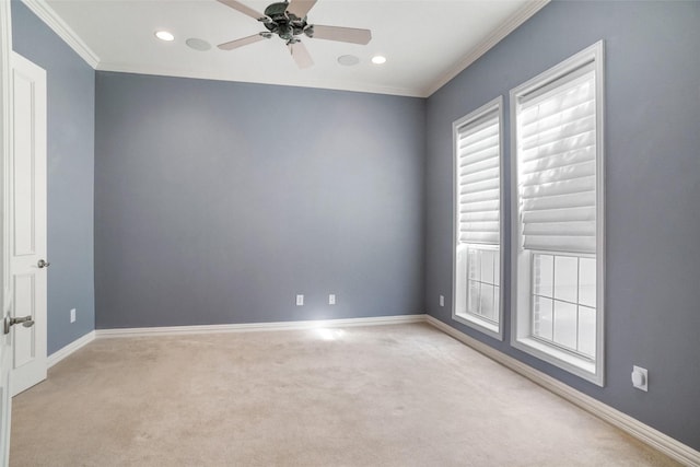 spare room with ceiling fan, light colored carpet, and crown molding