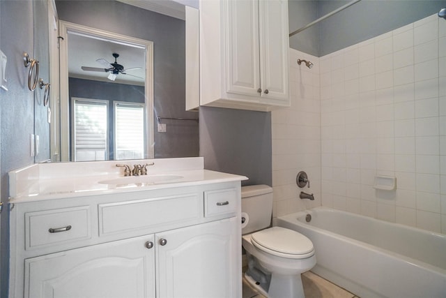 full bathroom featuring ceiling fan, toilet, tiled shower / bath, and vanity