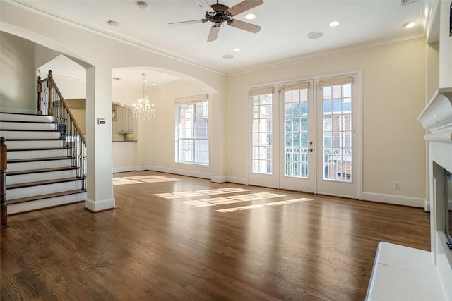 unfurnished living room with crown molding, dark wood-type flooring, and ceiling fan with notable chandelier