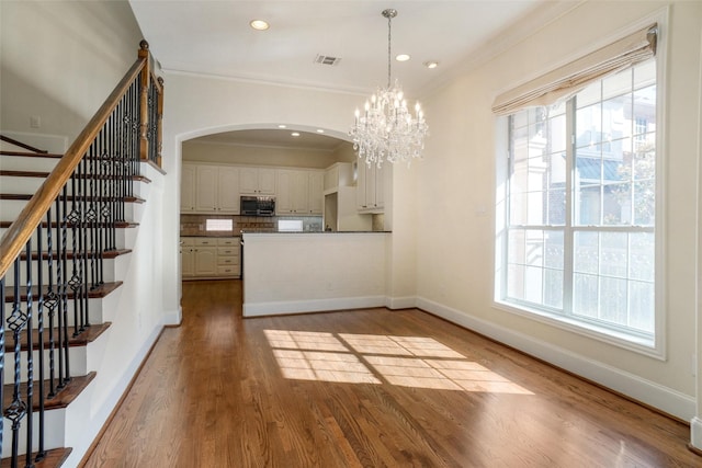 interior space featuring hardwood / wood-style flooring, crown molding, and a chandelier