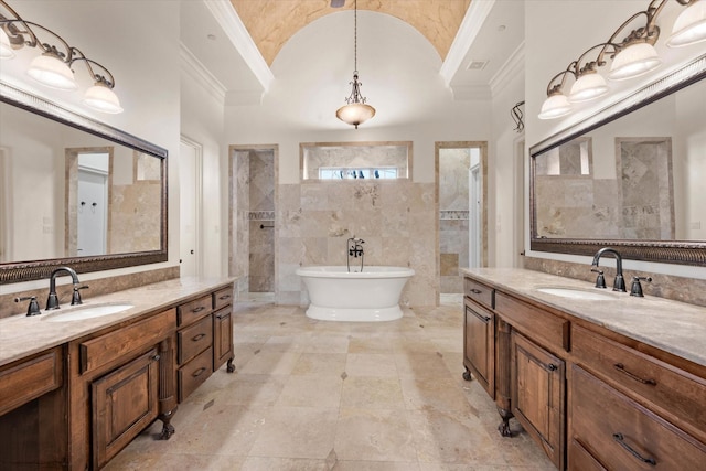 bathroom featuring a washtub, vanity, vaulted ceiling, and ornamental molding