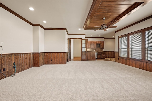 unfurnished living room featuring light carpet, crown molding, ceiling fan, and wooden ceiling