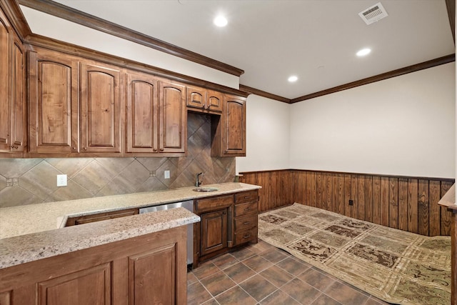 kitchen featuring light stone countertops, dishwasher, ornamental molding, and sink