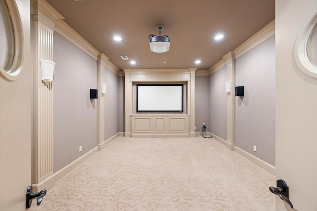 carpeted home theater room with crown molding