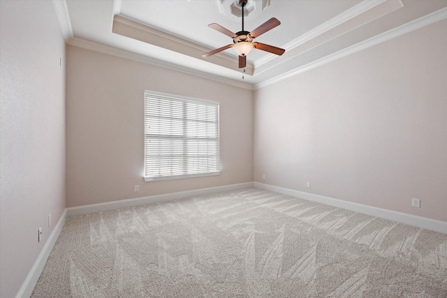 carpeted empty room featuring a tray ceiling, ceiling fan, and crown molding