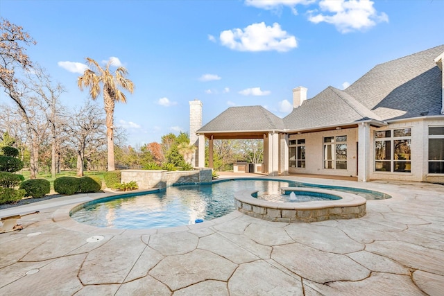 view of swimming pool featuring pool water feature, a patio area, and an in ground hot tub