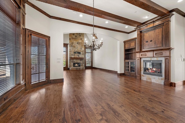 unfurnished living room with beam ceiling, an inviting chandelier, dark wood-type flooring, and crown molding