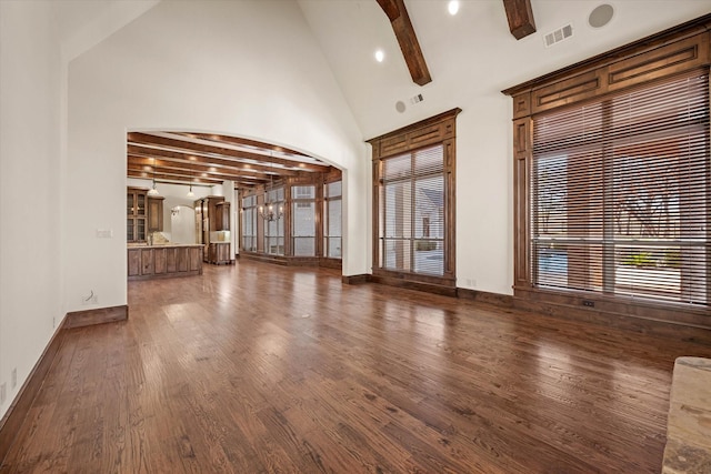 unfurnished living room featuring beam ceiling, high vaulted ceiling, dark wood-type flooring, and a notable chandelier