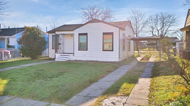 bungalow-style house featuring a front lawn and a carport