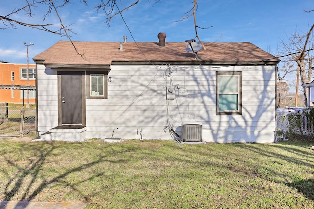 rear view of property with a yard and cooling unit