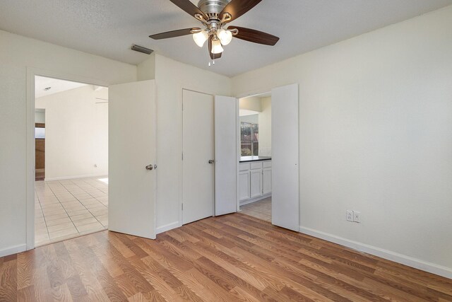 unfurnished bedroom with ceiling fan and light wood-type flooring