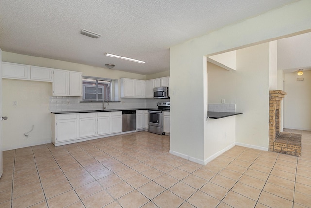 kitchen featuring backsplash, white cabinetry, stainless steel appliances, and light tile patterned floors