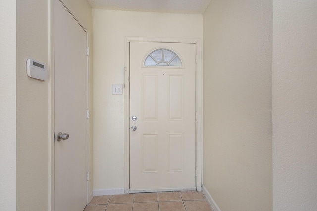 doorway with light tile patterned flooring