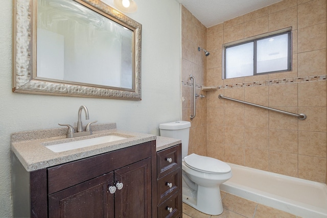 bathroom with tile patterned floors, vanity, toilet, and tiled shower