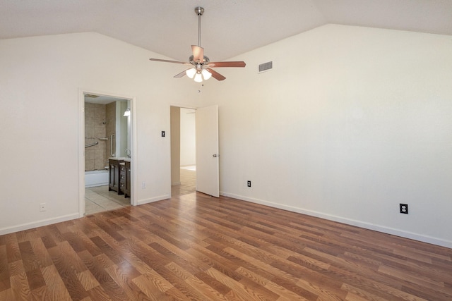 empty room with ceiling fan, wood-type flooring, and vaulted ceiling