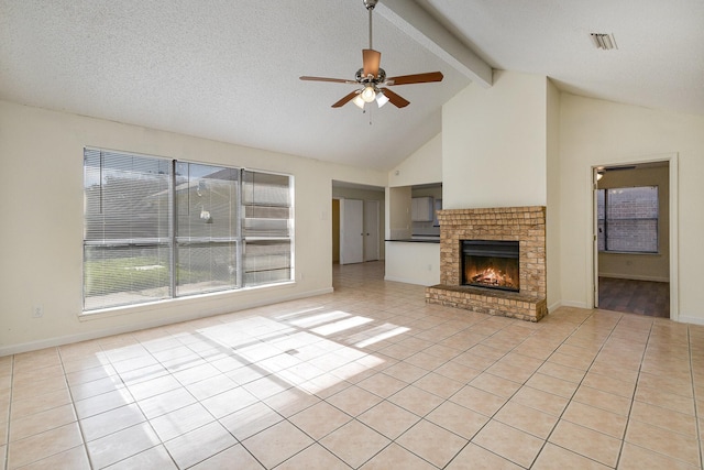 unfurnished living room with a brick fireplace, vaulted ceiling with beams, ceiling fan, light tile patterned floors, and a textured ceiling