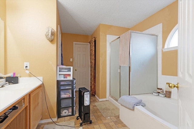 bathroom featuring vanity, a textured ceiling, and separate shower and tub