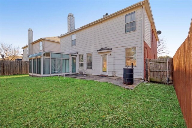 back of property with a lawn and a sunroom