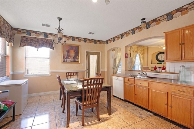 kitchen with dishwasher, a notable chandelier, pendant lighting, a textured ceiling, and light tile patterned floors