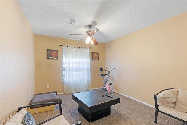 interior space with ceiling fan, carpet, and a textured ceiling