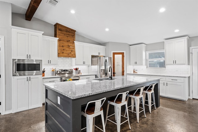 kitchen with white cabinetry, a center island with sink, and stainless steel appliances