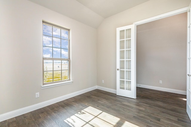 spare room with dark wood-type flooring, lofted ceiling, and french doors