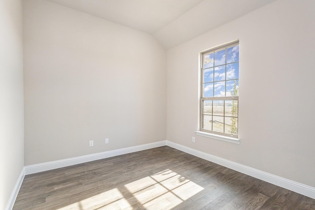 spare room featuring hardwood / wood-style flooring and vaulted ceiling