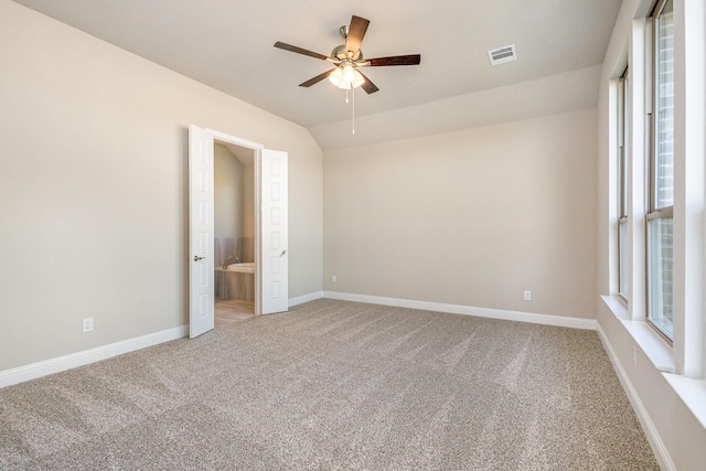 unfurnished bedroom featuring ceiling fan, carpet floors, ensuite bathroom, and lofted ceiling