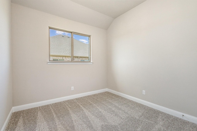 carpeted empty room featuring lofted ceiling