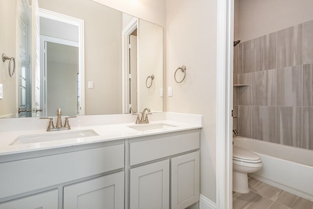 full bathroom featuring tiled shower / bath, vanity, and toilet