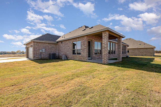 back of property featuring a garage, central AC unit, and a lawn