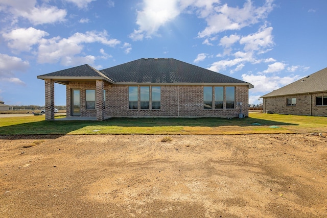 rear view of property featuring a lawn