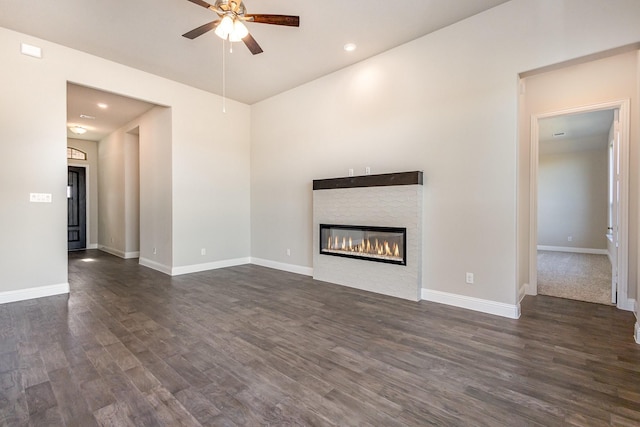 unfurnished living room featuring ceiling fan and dark wood-type flooring