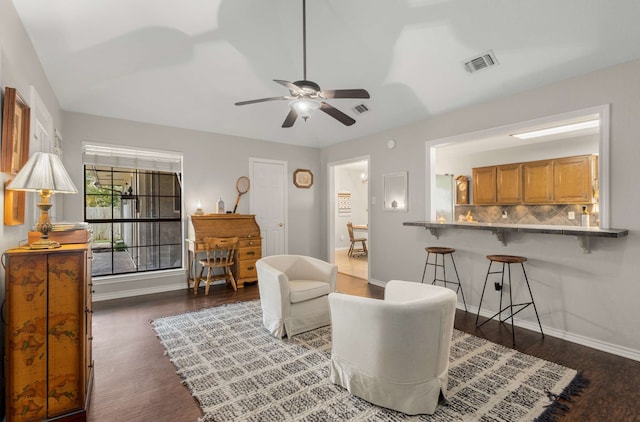 living area with ceiling fan and dark hardwood / wood-style floors