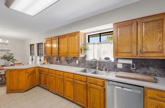 kitchen featuring dishwasher, sink, tasteful backsplash, kitchen peninsula, and a chandelier