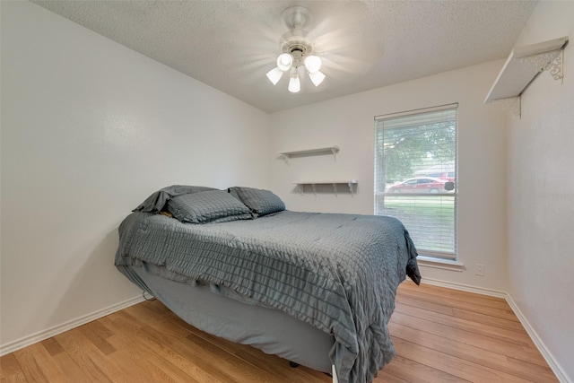 bedroom featuring multiple windows, ceiling fan, and light wood-type flooring