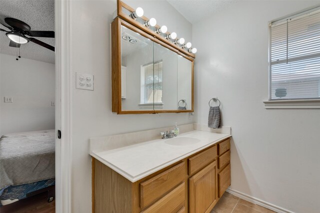 bathroom featuring tile patterned floors, ceiling fan, vanity, and a textured ceiling