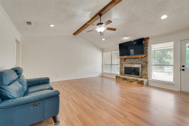 living room featuring a textured ceiling, lofted ceiling with beams, light hardwood / wood-style flooring, and ceiling fan