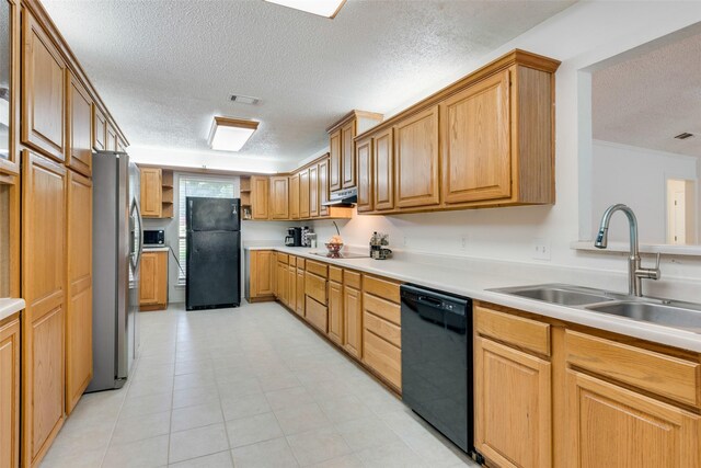 kitchen featuring black appliances, sink, exhaust hood, and a textured ceiling