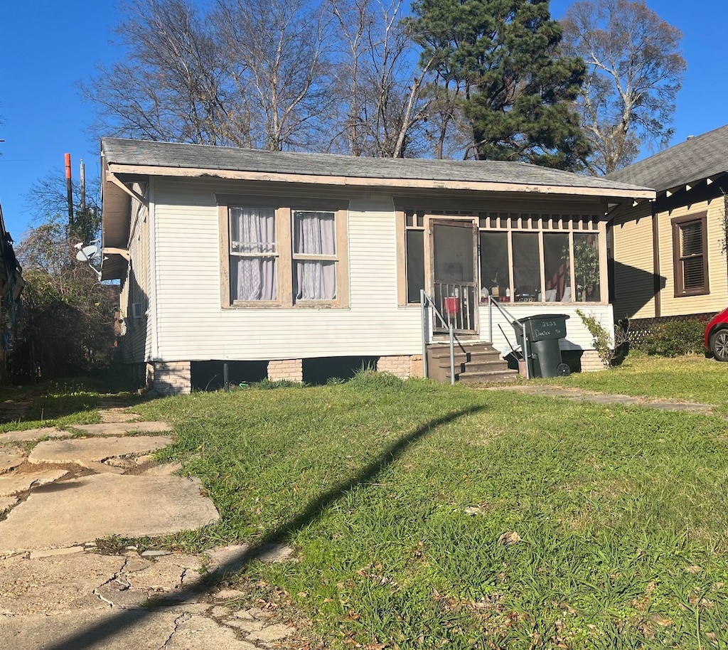 view of front of house featuring a front lawn and a sunroom