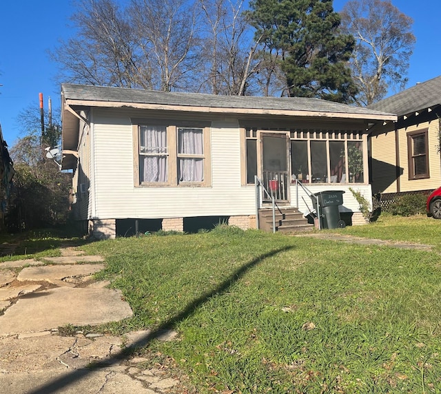 view of front of house featuring a front lawn and a sunroom