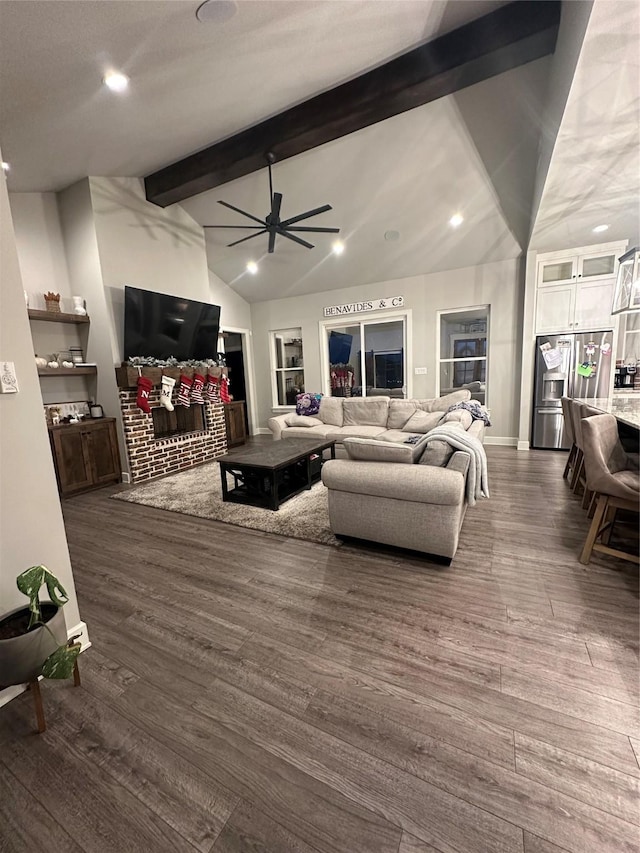 living room with lofted ceiling with beams, ceiling fan, and dark wood-type flooring