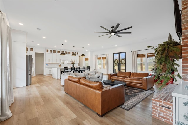 living room with ceiling fan and light hardwood / wood-style floors